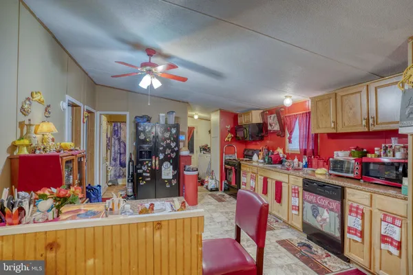 a kitchen filled with stainless steel appliances kitchen island granite countertop a table chairs in it and wooden floors