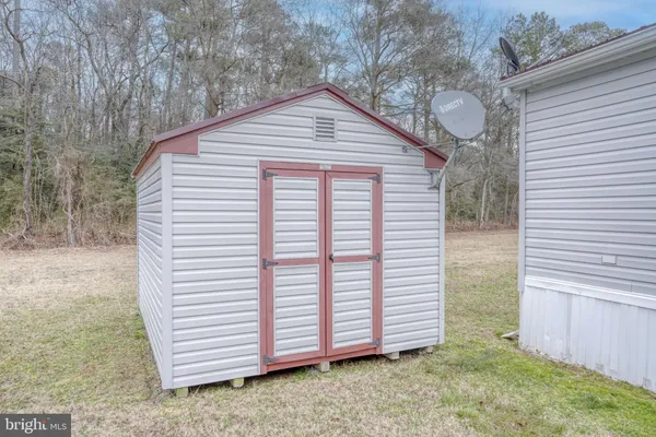 a view of a small house with a yard and wooden fence