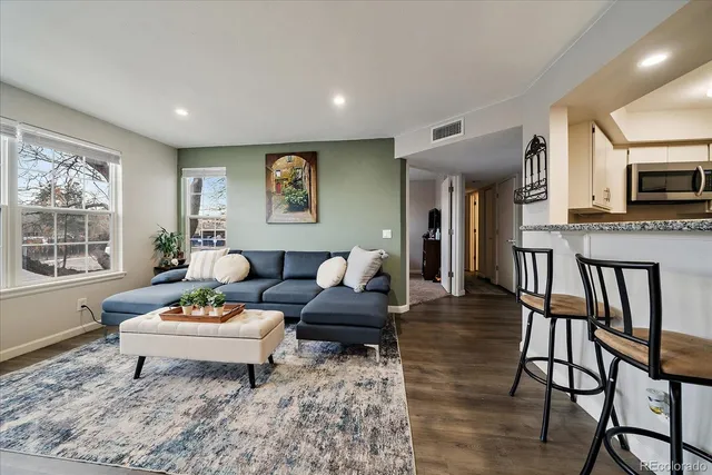 a living room with furniture a flat screen tv and a table