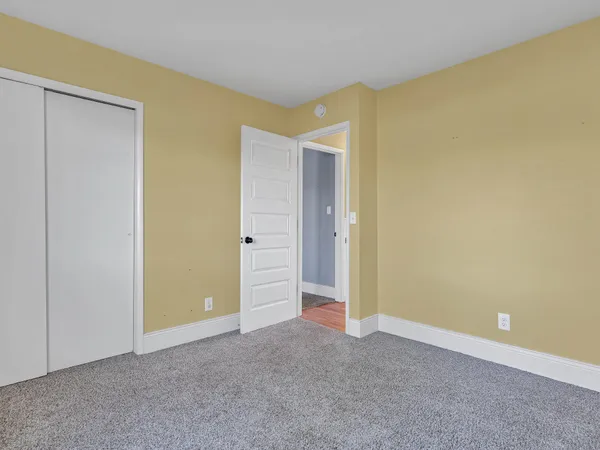 a view of a house with a big yard and large trees