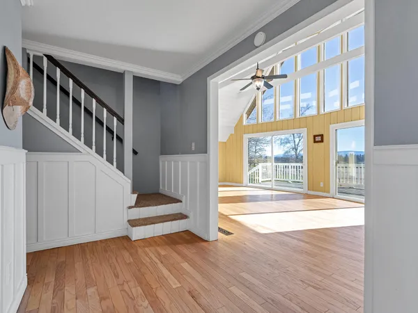 a view of a hallway with wooden floor and entryway
