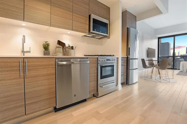 a kitchen with stainless steel appliances granite countertop a stove a sink and a refrigerator