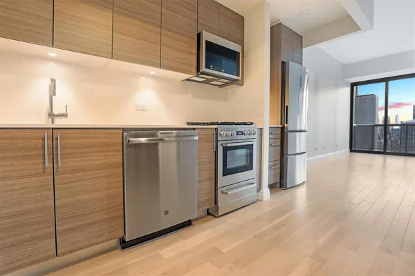 a kitchen with stainless steel appliances wooden floor and granite counter tops