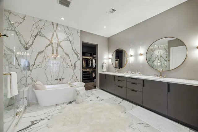 a bathroom with a double vanity sink mirror and bathtub