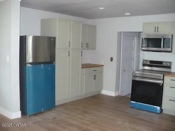a kitchen with stainless steel appliances a refrigerator and a stove top oven