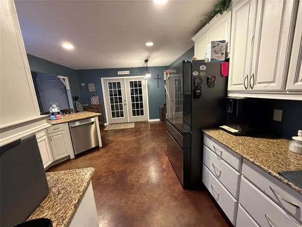 a kitchen with stainless steel appliances granite countertop a refrigerator and a sink