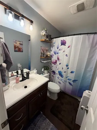 a bedroom with a large bed a flat tv screen and a ceiling fan