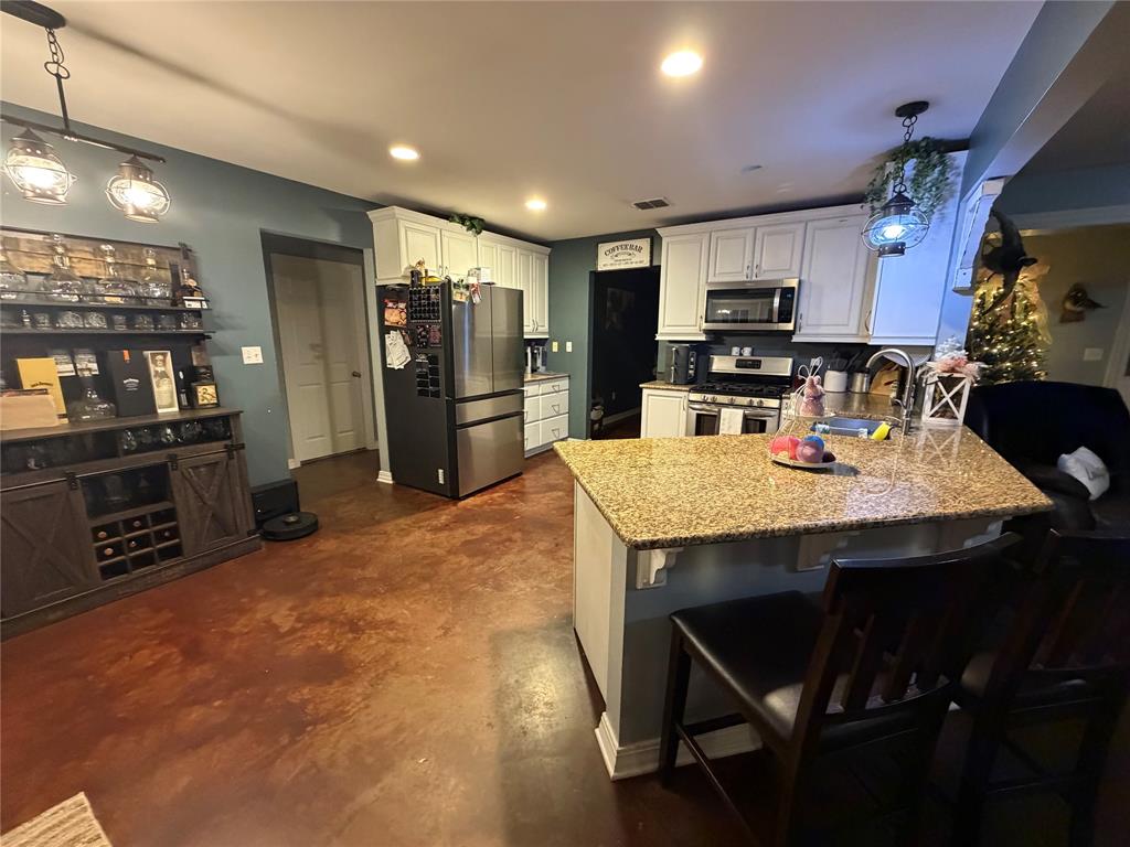 128 Staton Drive Haughton, LA 71037 - Photo 10 of 29 a kitchen with stainless steel appliances a dining table chairs and refrigerator