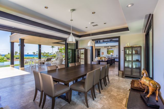a dining room with furniture a chandelier and wooden floor