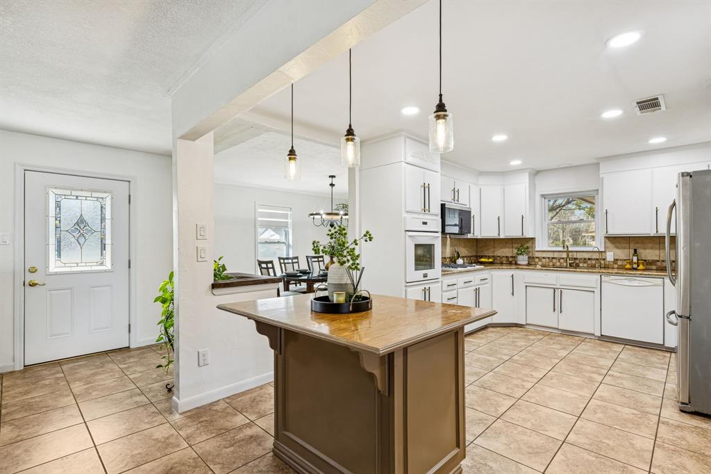 1012 Cowling Road Sanger, TX 76266 - Photo 12 of 40 a kitchen with kitchen island a counter top space appliances and cabinets