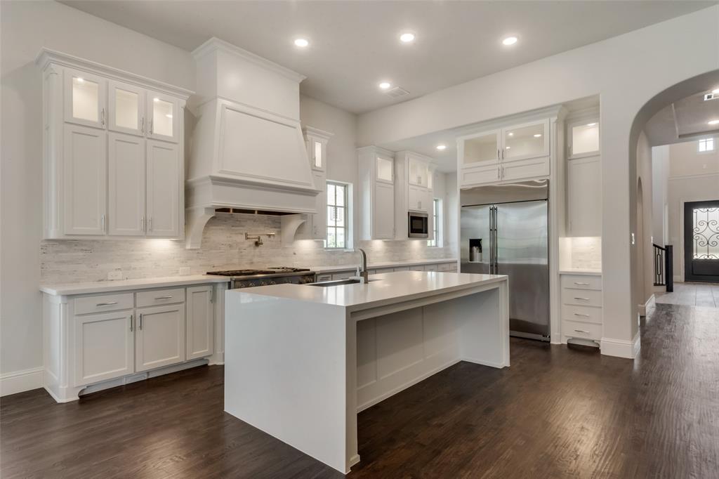6887 Tranquility Court Frisco, TX 75034 - Photo 11 of 37 a kitchen with stainless steel appliances granite countertop a stove and white cabinets