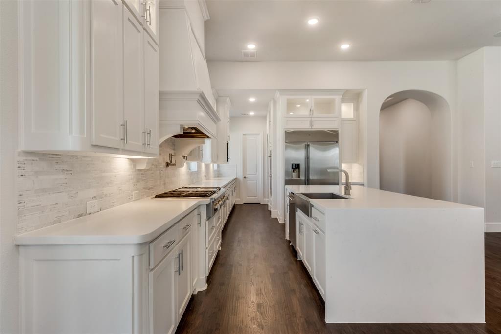 6887 Tranquility Court Frisco, TX 75034 - Photo 12 of 37 a kitchen with a stove and a wooden floors