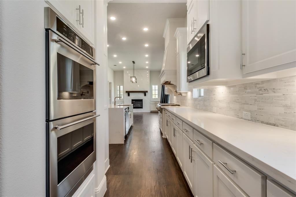 6887 Tranquility Court Frisco, TX 75034 - Photo 13 of 37 a kitchen with a sink stainless steel appliances and cabinets