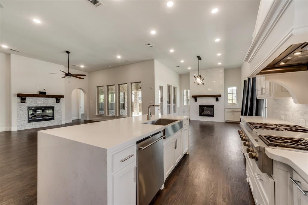 6887 Tranquility Court Frisco, TX 75034 - Photo 14 of 37 a large kitchen with stainless steel appliances granite countertop a stove and a refrigerator