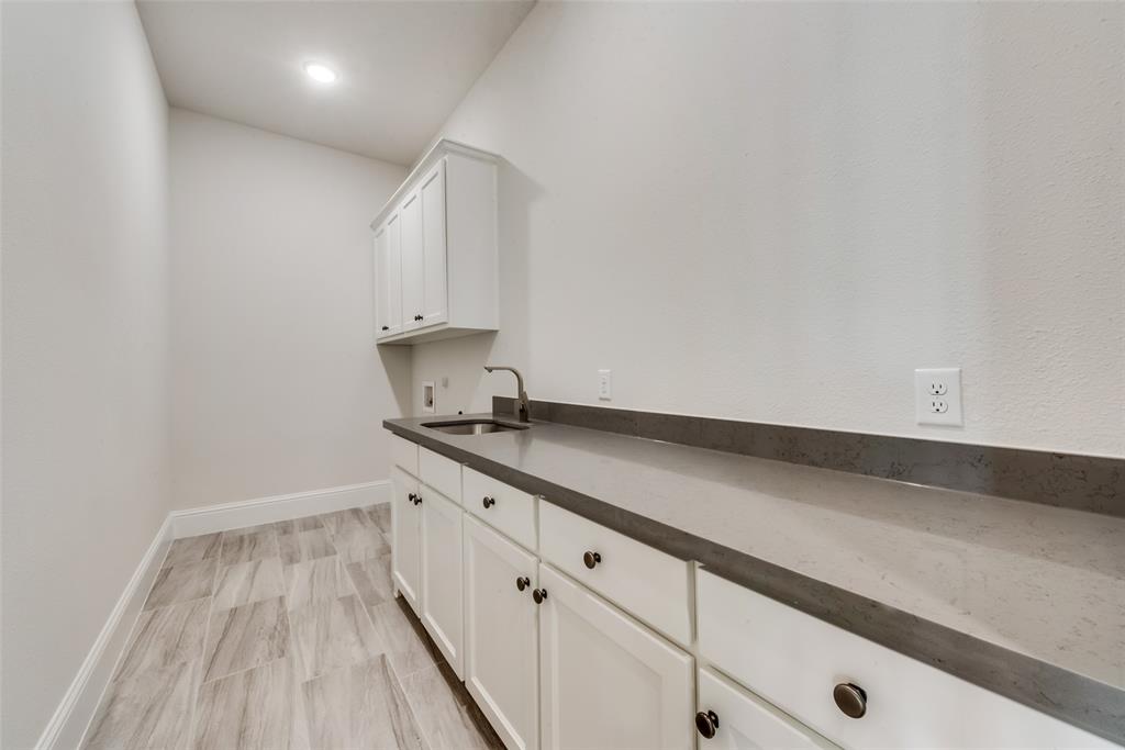 6887 Tranquility Court Frisco, TX 75034 - Photo 23 of 37 a kitchen with granite countertop white cabinets and white appliances