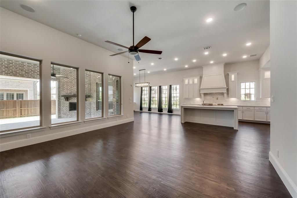 6887 Tranquility Court Frisco, TX 75034 - Photo 9 of 37 a view of an empty room with wooden floor and a kitchen