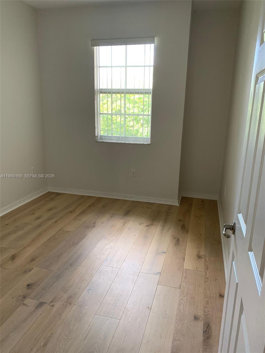 8440 West McNab Road, Unit 8440 Fort Lauderdale, FL 33321 - Photo 17 of 22 an empty room with wooden floor and windows