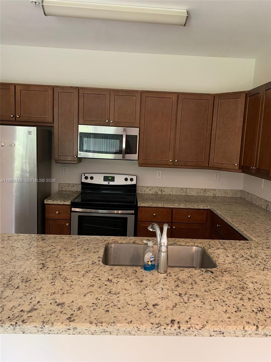 8440 West McNab Road, Unit 8440 Fort Lauderdale, FL 33321 - Photo 18 of 22 a kitchen with a refrigerator sink and stove