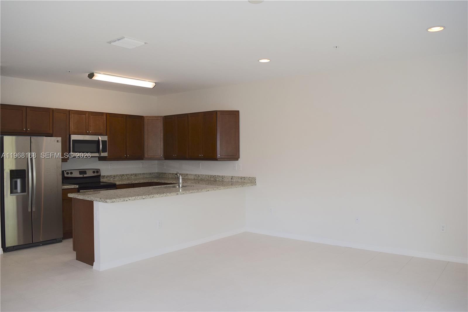 8440 West McNab Road, Unit 8440 Fort Lauderdale, FL 33321 - Photo 5 of 22 a kitchen with stainless steel appliances a refrigerator and a stove top oven