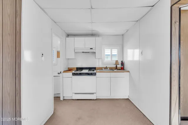 a kitchen with a stove and white cabinets