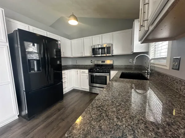 a view of a livingroom with wooden floor and staircase