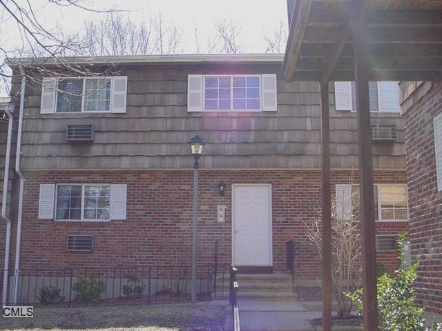 215 Edgemoor Road, Unit L 12 Bridgeport, CT 06606 - Photo 1 of 1 a brick building with a bench and large windows