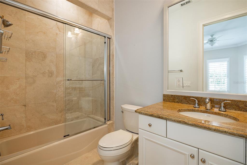 821 Bay Point Drive Madeira Beach, FL 33708 - Photo 27 of 66 a bathroom with a granite countertop sink a toilet and shower
