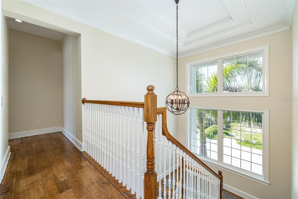 821 Bay Point Drive Madeira Beach, FL 33708 - Photo 28 of 66 a view of a hallway to room with wooden floor and windows