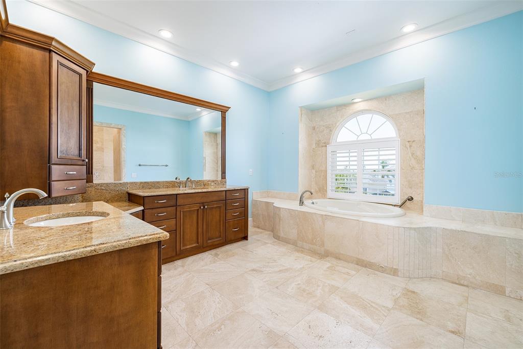821 Bay Point Drive Madeira Beach, FL 33708 - Photo 36 of 66 a spacious bathroom with a tub sink and mirror