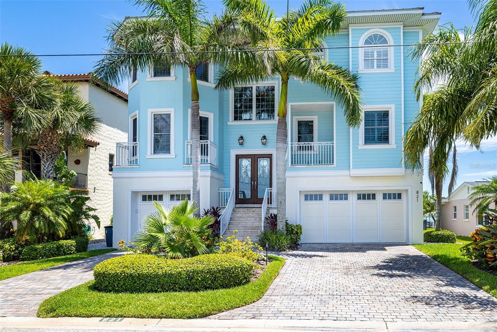 821 Bay Point Drive Madeira Beach, FL 33708 - Photo 51 of 66 a front view of a house with a yard and garage