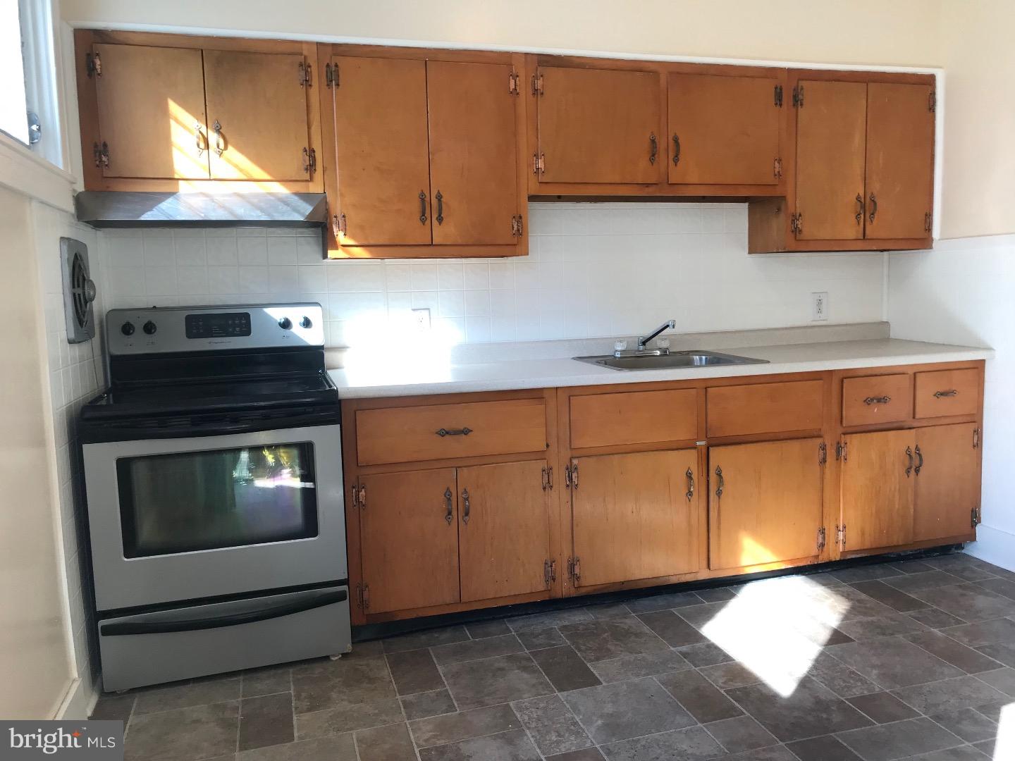 212 Wembly Road Upper Darby, PA 19082 - Photo 5 of 12 a kitchen with granite countertop white cabinets stainless steel appliances and sink