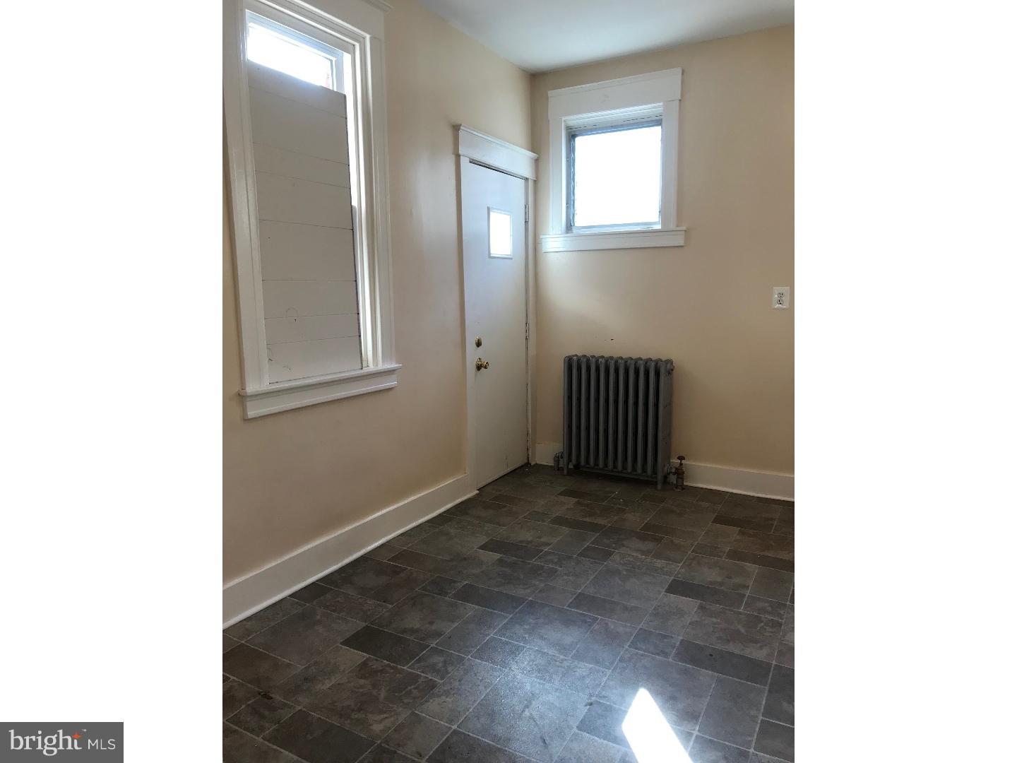 212 Wembly Road Upper Darby, PA 19082 - Photo 6 of 12 a view of an empty room with wooden floor and a mirror