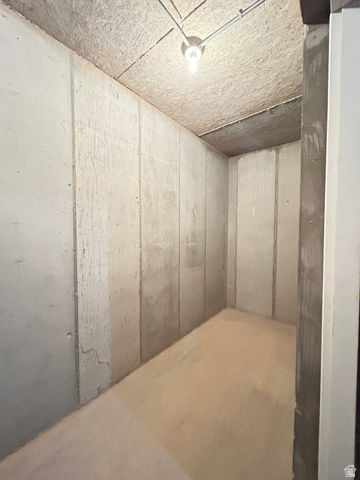 6 South 450th West Gunnison, UT 84634 - Photo 43 of 45 Concrete walls featuring vertical panel divisions, a light-colored concrete floor, and an exposed bulb fixture on the ceiling