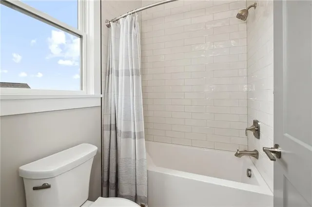 a white bath tub sitting next to a white toilet and a shower