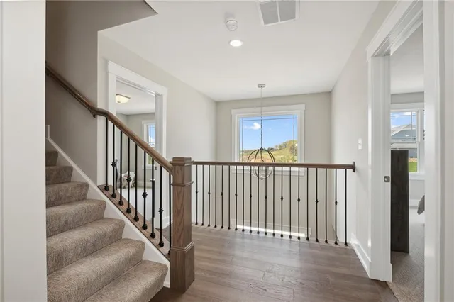 a view of a hallway with wooden floor and staircase