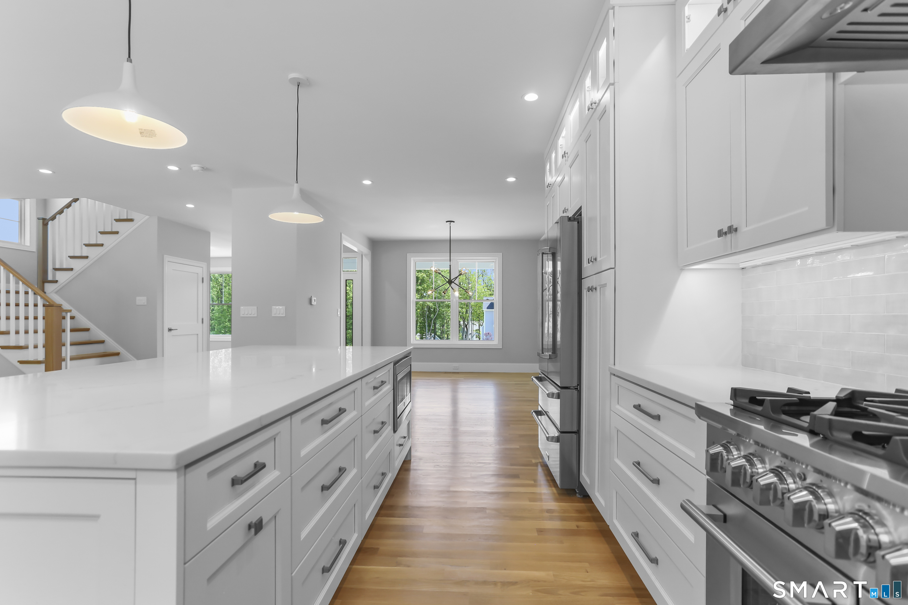 110 Porters Hill Road Trumbull, CT 06611 - Photo 17 of 47 a large kitchen with kitchen island a large counter top space a sink stainless steel appliances and a chandelier