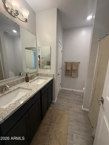 a bathroom with a granite countertop sink a large mirror and a shower