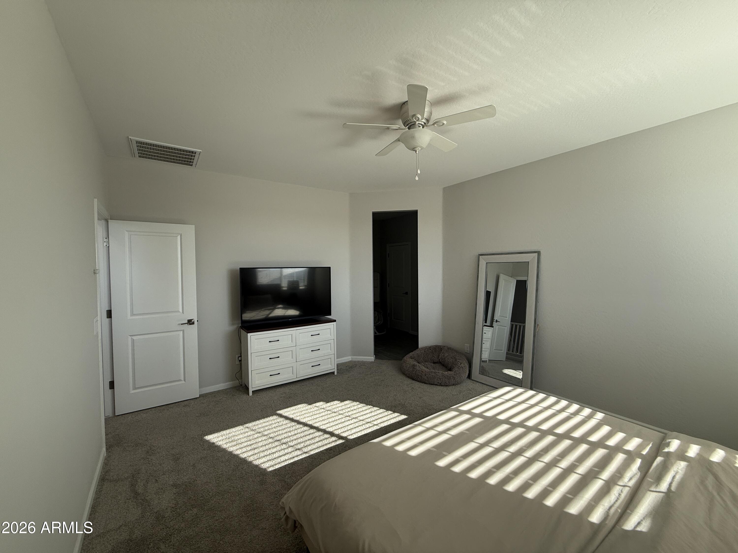 18140 West Daley Lane Surprise, AZ 85387 - Photo 14 of 23 a bedroom with a bed and a flat screen tv