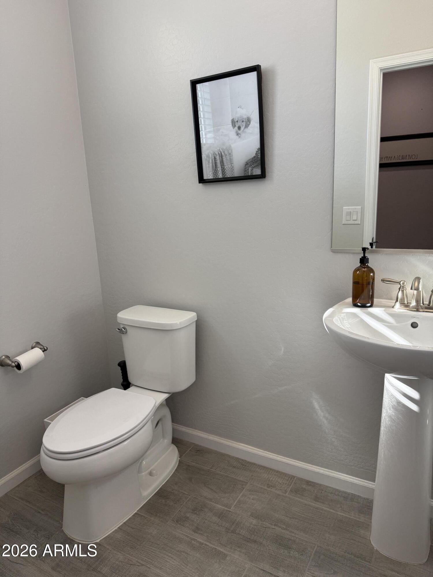 18140 West Daley Lane Surprise, AZ 85387 - Photo 5 of 23 a white toilet sitting next to a bathroom sink