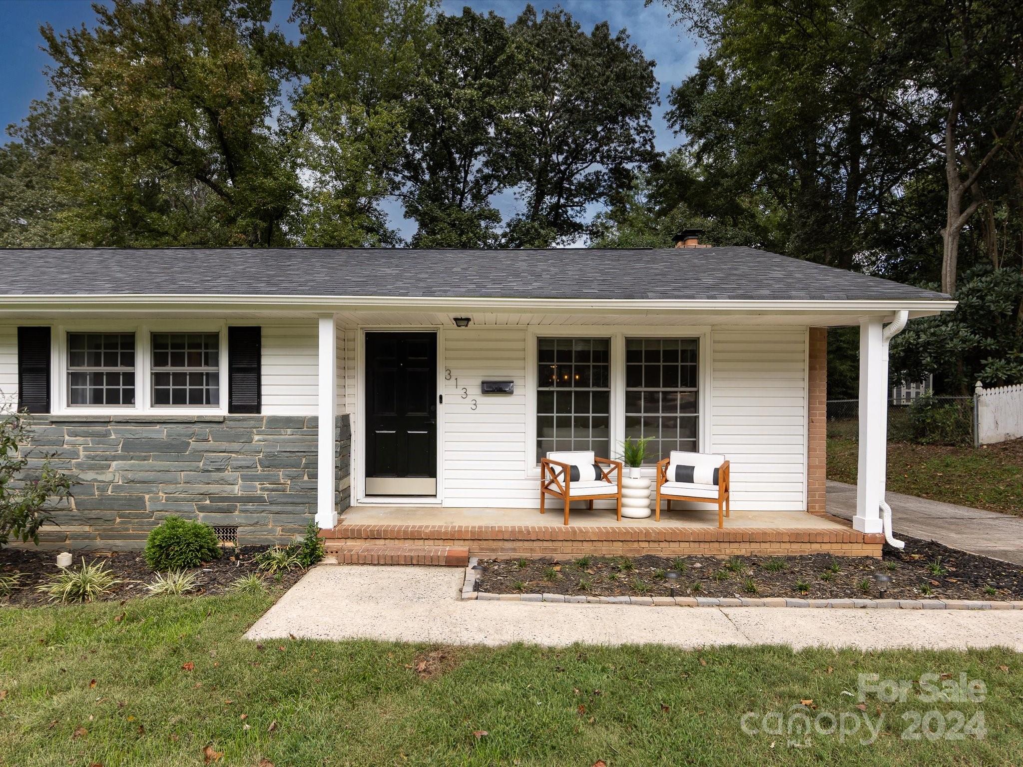 3133 Spring Valley Road Charlotte, NC 28210 - Photo 2 of 25 a front view of a house with garden and chairs