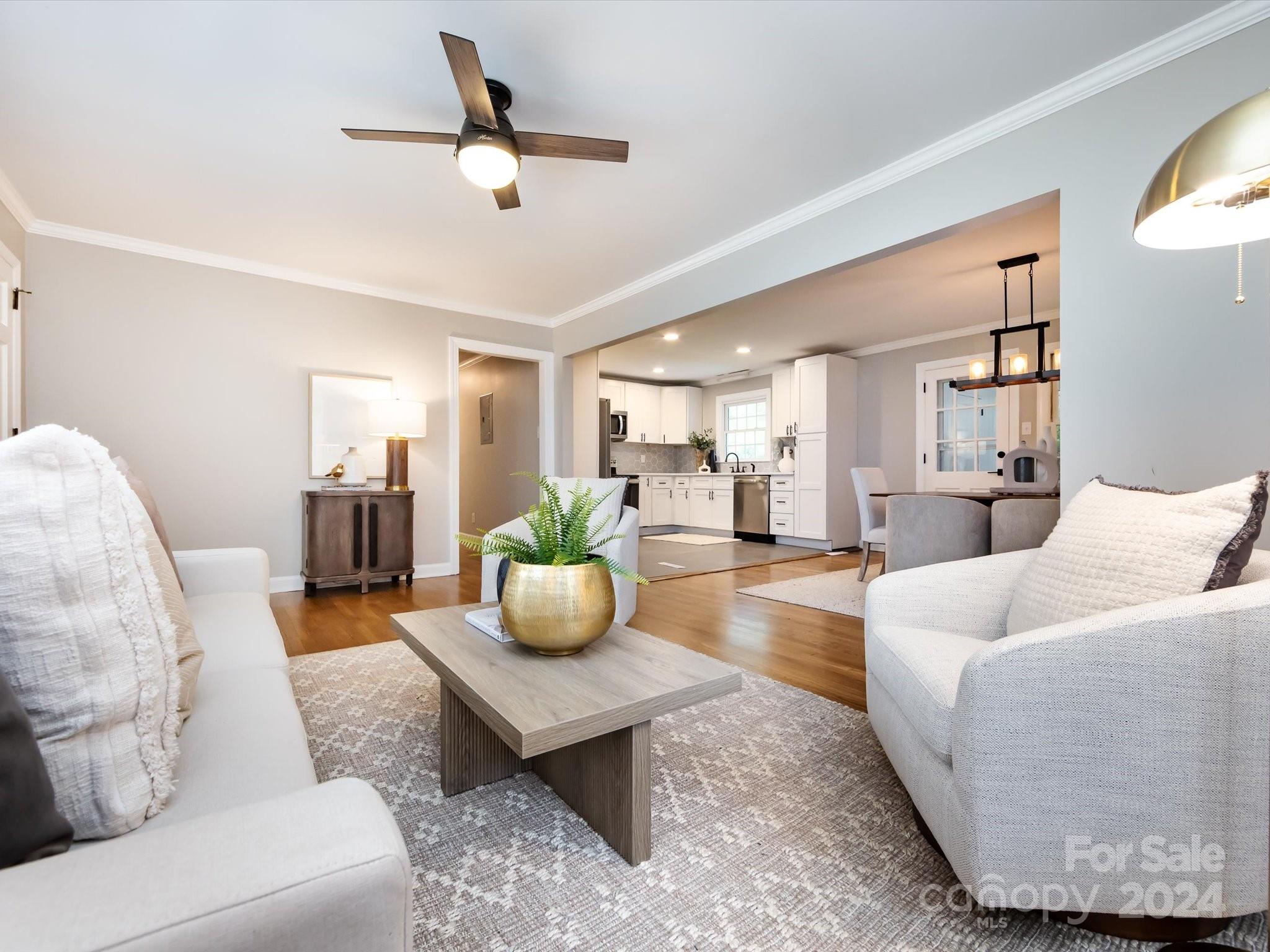 3133 Spring Valley Road Charlotte, NC 28210 - Photo 8 of 25 a living room with furniture a rug and a chandelier