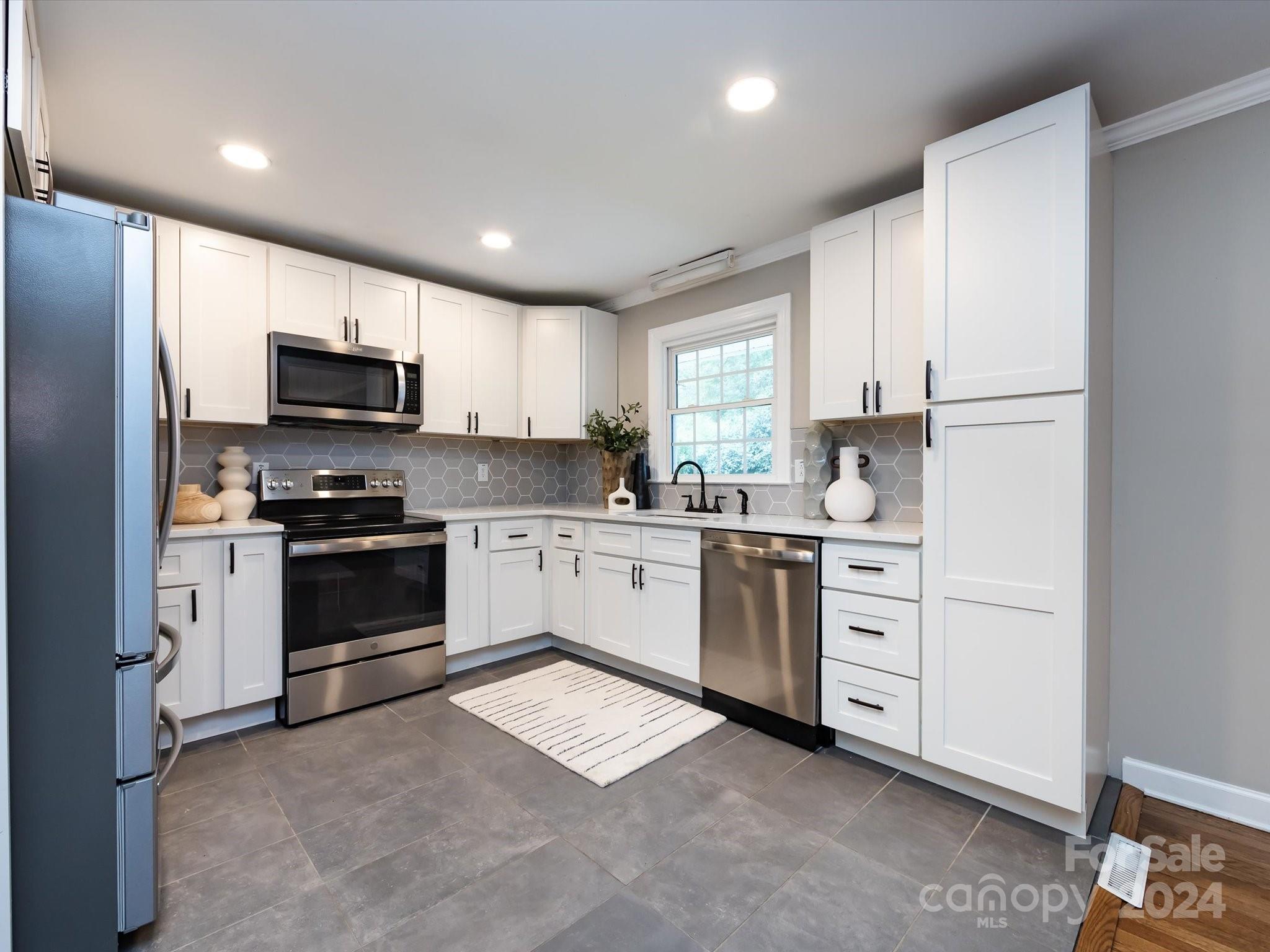 3133 Spring Valley Road Charlotte, NC 28210 - Photo 10 of 25 a kitchen with granite countertop white cabinets and stainless steel appliances