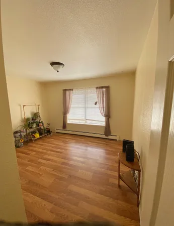 a view of a livingroom with wooden floor and a window