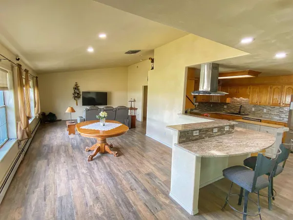 a kitchen with a table chairs stove and kitchen view