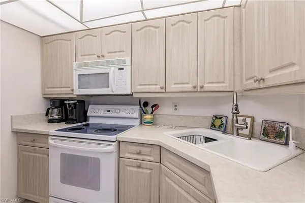 a kitchen with white cabinets and white appliances