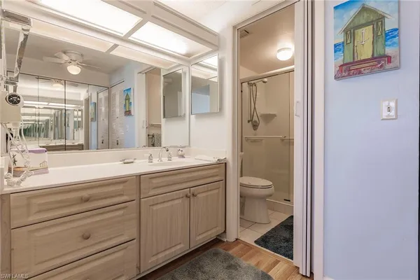 a bathroom with a granite countertop toilet a sink and a large mirror