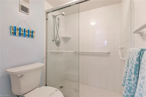 a white toilet sitting next to a shower