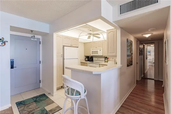 a view of kitchen with kitchen island wooden floor and refrigerator