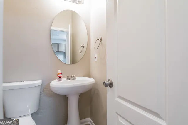 a bathroom with a sink mirror and toilet