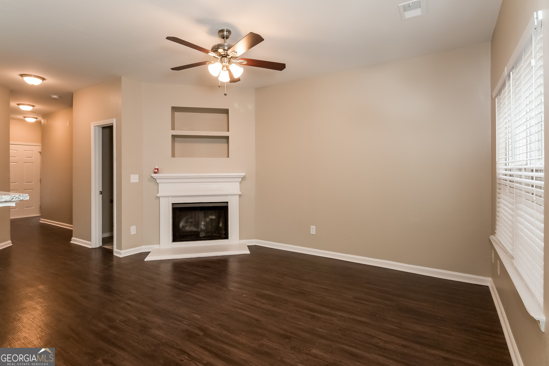 2839 Windsor Forrest Court College Park, GA 30349 - Photo 3 of 15 a view of a livingroom with a fireplace a ceiling fan and windows